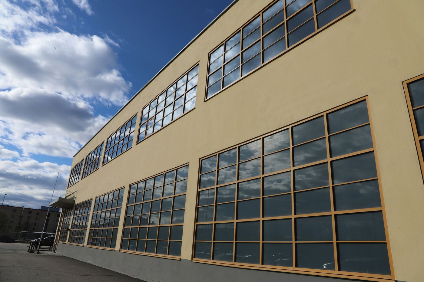 Two-storey warehouse with large grid windows under a blue sky