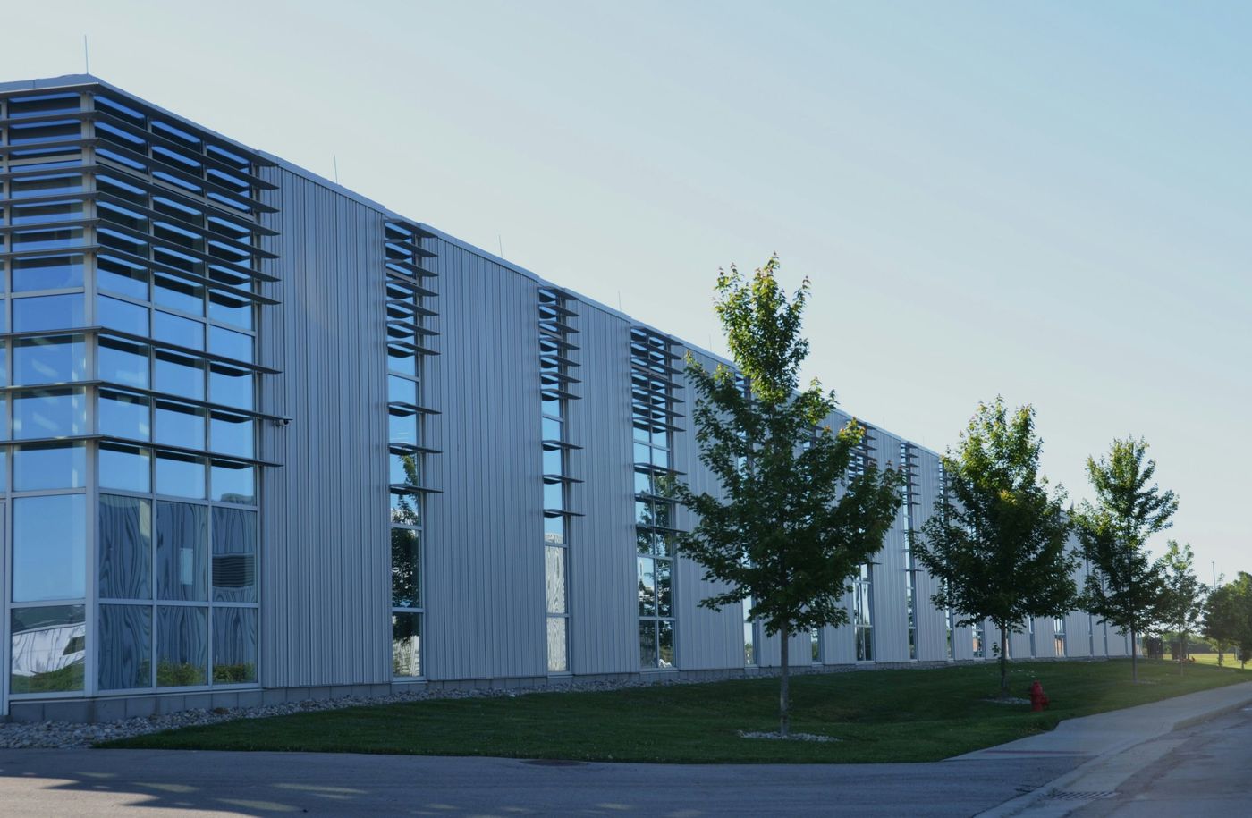 Long industrial building with glazed bays and young trees